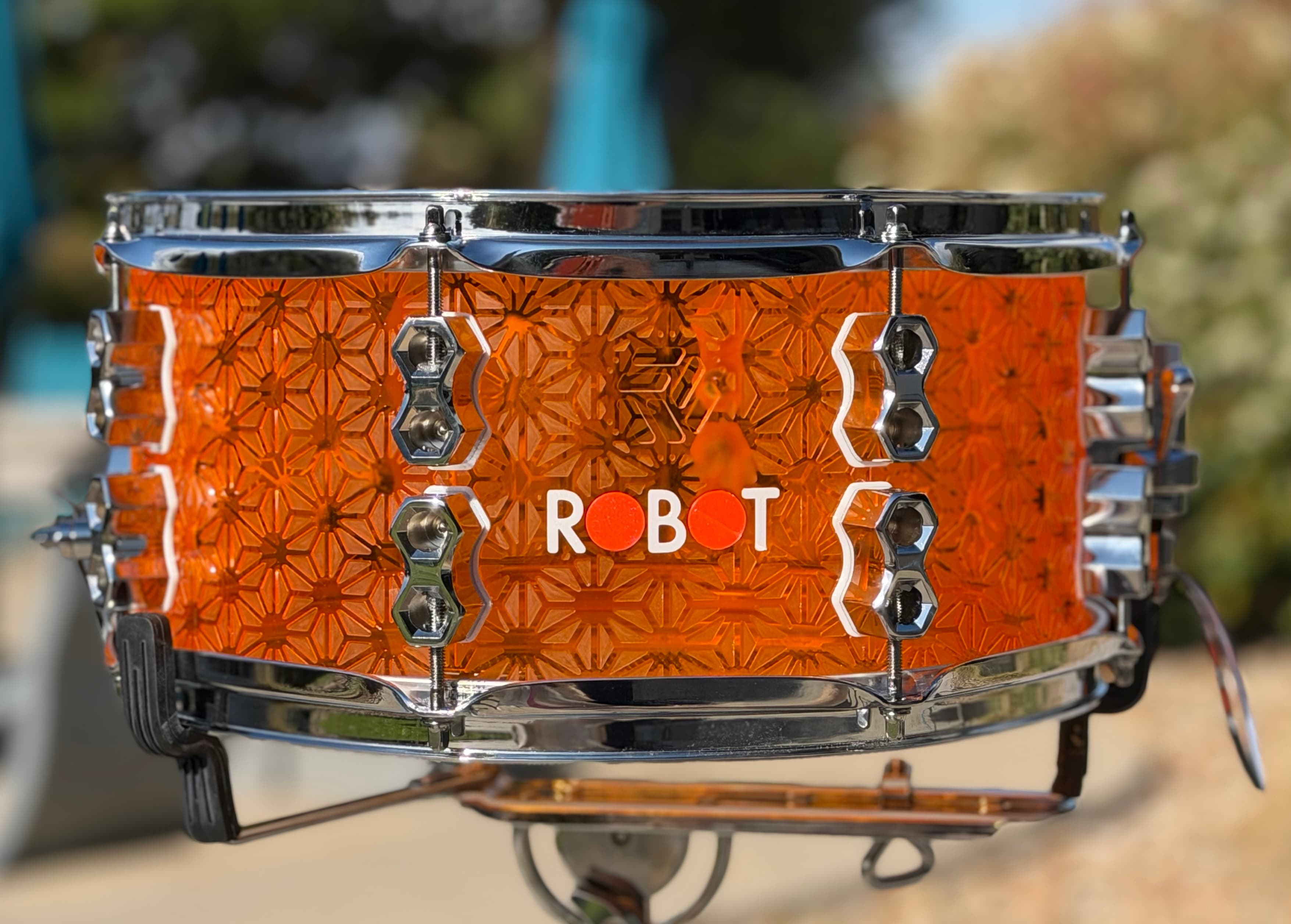 Asanoha Series snare with an orange geometric shell and chrome hardware.